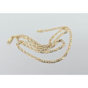 May include: A gold-toned chain necklace with a delicate, textured design. The necklace features a series of interconnected, rectangular links with starburst and geometric patterns. The chain is displayed on a white background.