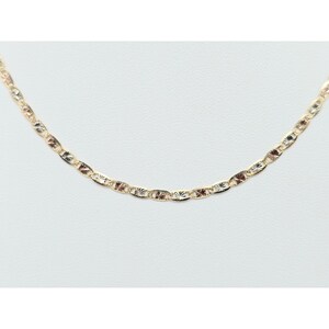 May include: A delicate gold-colored chain necklace with a repeating pattern of oval and star-shaped links. The necklace is displayed on a white background, showcasing its intricate design and subtle shine. The chain is approximately 18 inches long.