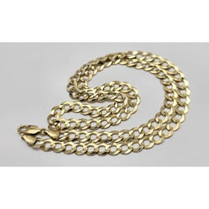 May include: A gold-colored curb chain necklace. The necklace is made of interlocking oval links and has a lobster clasp closure. The chain is displayed on a white background.