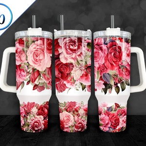 May include: Three white stainless steel tumblers with a floral design featuring pink and red roses. Each tumbler has a white lid and a white handle.