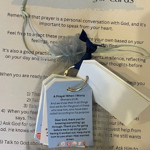 May include: A set of prayer cards for preteens and teens. The cards are decorated with a light blue ribbon and have a white background with black text. The text on the cards includes a prayer for when you worry, and steps for praying.
