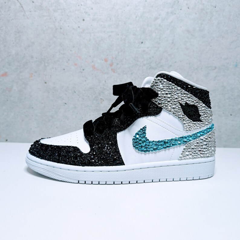 May include: White and black high-top sneakers with a blue swoosh and rhinestones.