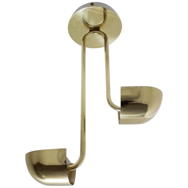 May include: A brass ceiling light fixture with two curved shades. The fixture has a circular canopy and a long, curved arm that connects to the shades.