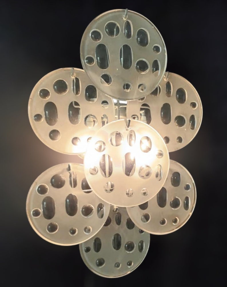 May include: A modern, white, glass pendant light fixture with a cluster of round, textured, frosted glass shades. The shades have a pattern of small, round holes.
