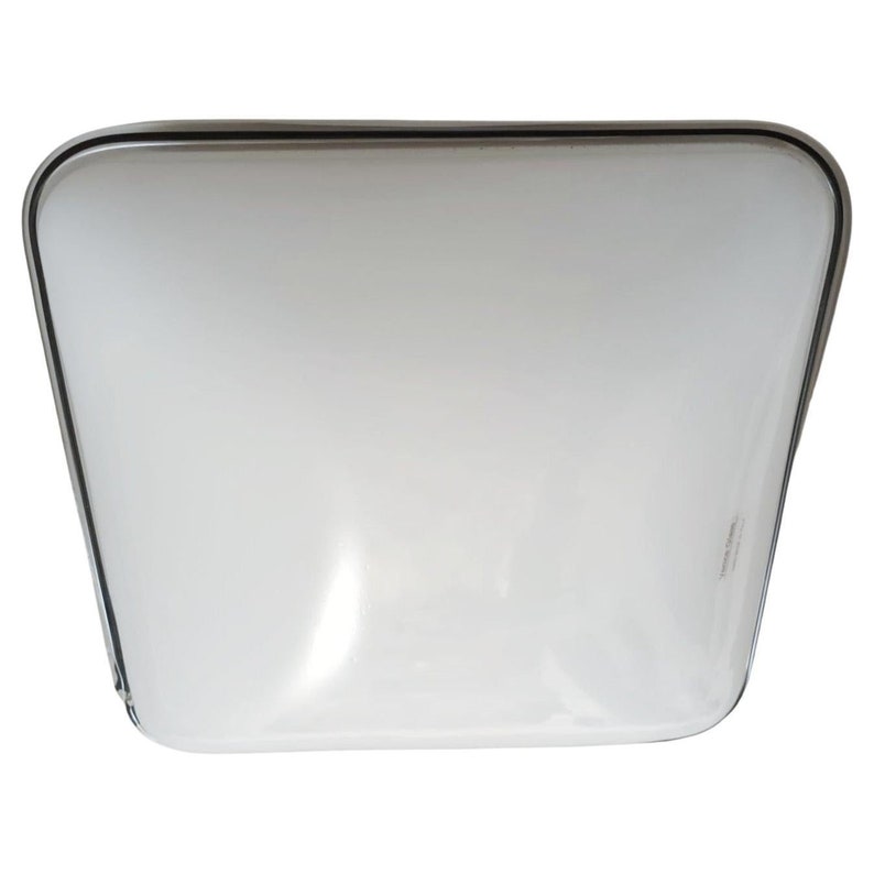 May include: A white square ceiling light fixture with a black trim.