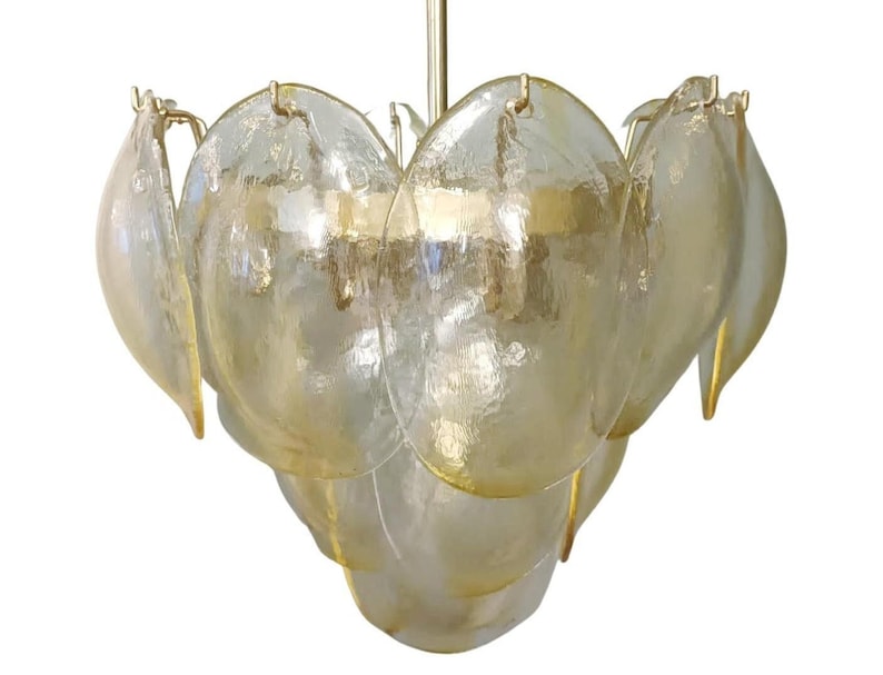 May include: A vintage chandelier with a layered design of petal-shaped glass shades in shades of yellow and gold. The glass has a textured appearance, and the fixture is suspended from a gold-colored metal rod.