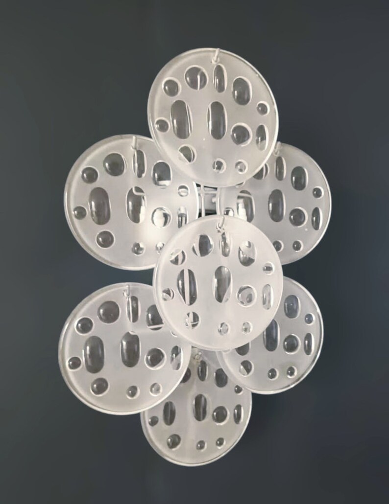 May include: A set of seven white, round, decorative wall sconces with a unique, textured, bubble-like design.