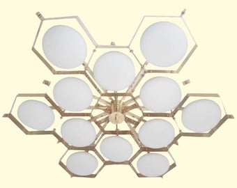 May include: A brass and glass chandelier with a honeycomb design. The chandelier has 12 white glass globes and a brass frame.