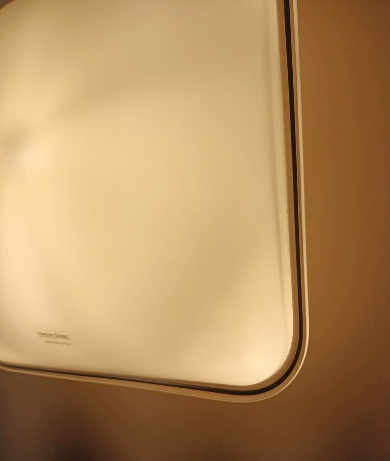 May include: A white ceiling light fixture with a black trim. The light fixture has a frosted glass cover and the text "Zenith Glass" is printed on the bottom.
