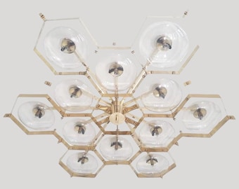 May include: A gold-toned chandelier with a honeycomb design and clear glass globes. The chandelier has 12 lights and is suspended from a central point.
