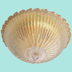 May include: A gold-toned glass ceiling light fixture with a scalloped edge and a textured, ribbed design.