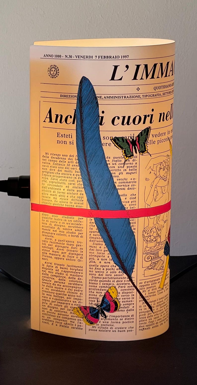 May include: A vintage newspaper clipping with a blue and black feather, a red and yellow butterfly, and the text "Anchi cuori nell'" in Italian. The newspaper is yellowed and has a vintage aesthetic.