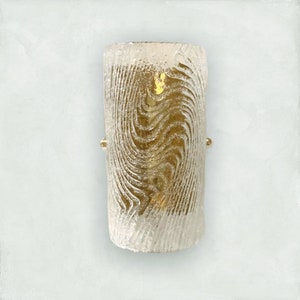 May include: A gold-toned wall sconce with a clear glass shade featuring a swirling, textured pattern.