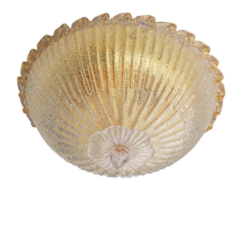 May include: A gold and white glass ceiling light fixture with a scalloped edge and a textured surface.