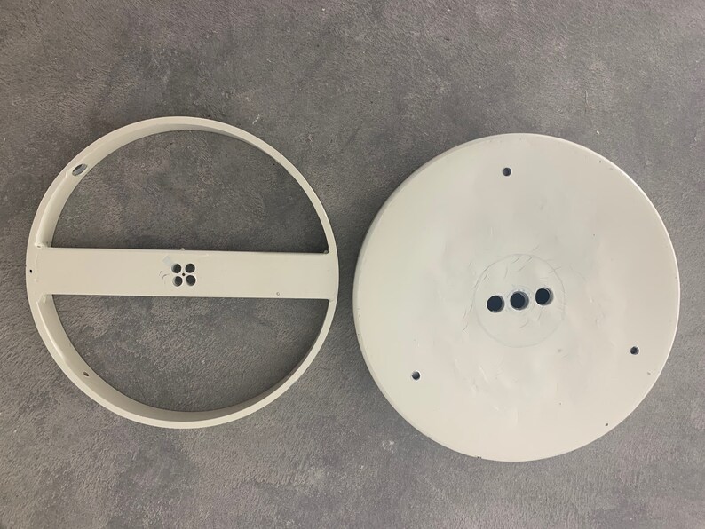 May include: Two white plastic ceiling light fixture parts. One part is a round ring with a crossbar and four small holes. The other part is a round disc with three holes.