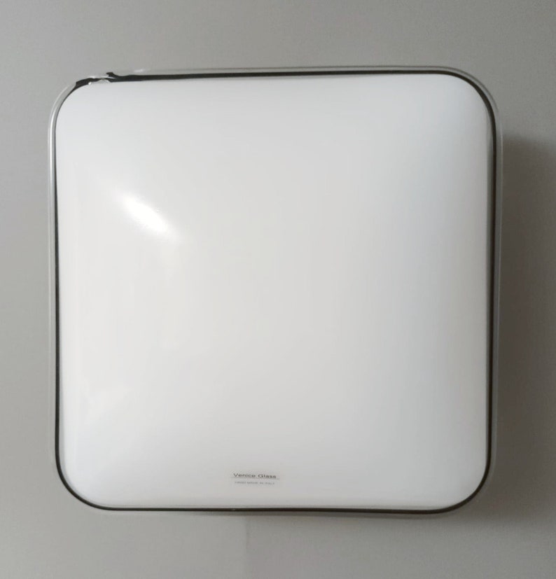 May include: A white square ceiling light fixture with a black trim and the text "Venice Glass" on the bottom.