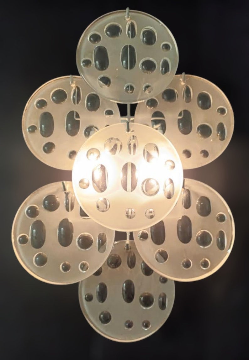 May include: A white ceiling light fixture with multiple round, frosted glass shades. Each shade has a pattern of small, round holes.