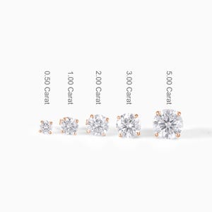 May include: A collection of five diamond stud earrings in varying sizes, ranging from 0.50 to 5.00 carats. Each earring features a round, brilliant-cut diamond set in a rose gold setting. The carat size is labeled next to each earring.