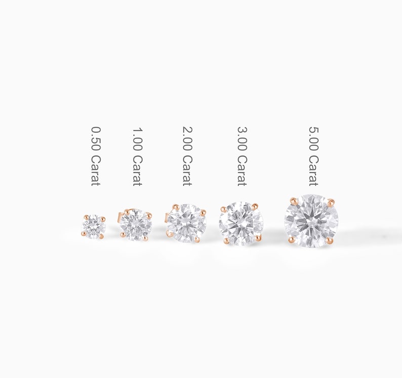 May include: A collection of five diamond stud earrings in varying sizes, ranging from 0.50 to 5.00 carats. Each earring features a round, brilliant-cut diamond set in a rose gold setting. The carat size is labeled next to each earring.