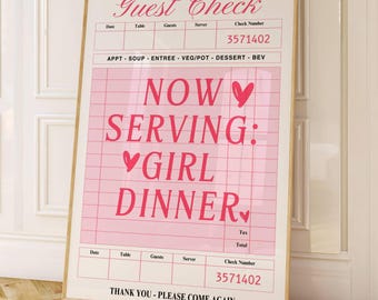 Könnte beinhalten: Ein gerahmtes rosa und weißes "Guest Check"-Schild mit dem Text "NOW SERVING: GIRL DINNER". Das Schild lehnt an einer weißen Wand und einer weißen Tür. Das Schild hat einen goldenen Rahmen.