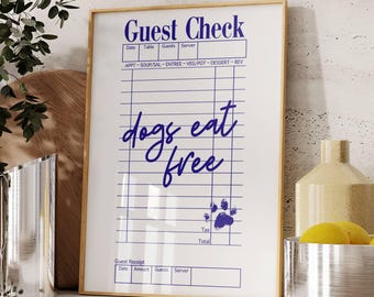 May include: A framed sign with a white background and blue text that reads "Guest Check" and "dogs eat free". The sign has a paw print graphic and a blank check-like form with lines for writing.