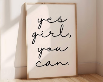 May include: A framed print with the text "yes girl, you can." in black cursive script on a white background.