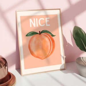 Puede incluir: Una impresión enmarcada con una ilustración de melocotón y la palabra "NICE" en texto blanco sobre un fondo melocotón.