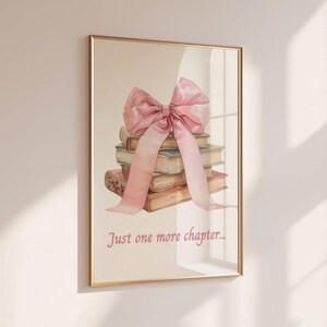 May include: A framed print featuring a watercolour illustration of a stack of books tied with a large pink bow. The text "Just one more chapter..." is printed below the books.