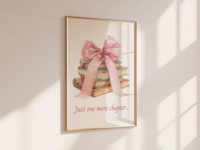 May include: A framed print featuring a watercolour illustration of a stack of books tied with a large pink bow. The text "Just one more chapter..." is printed below the books.