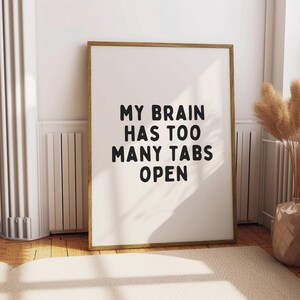 May include: A framed print with a white background and black text that reads "My brain has too many tabs open".
