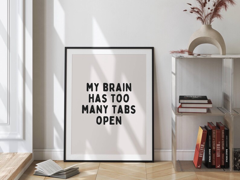 May include: A black framed print with a white background and black text that reads "My brain has too many tabs open".
