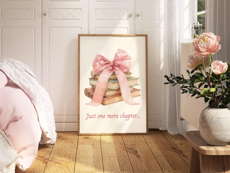 May include: A framed print featuring a watercolour illustration of a stack of books tied with a pink ribbon. The text "Just one more chapter..." is printed below the illustration.