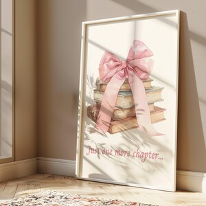 May include: A stack of books tied together with a large pink bow. The books are a light brown colour and have a vintage look. The text "Just one more chapter..." is printed below the books.