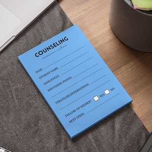 May include: A light blue notepad with the word "COUNSELING" at the top, followed by lines for notes. The notepad includes sections for date, student name, goal/focus, discussion points, strategies/interventions, and follow-up needed.