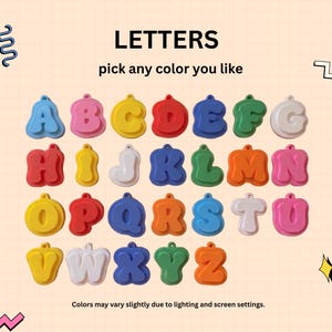 May include: A collection of twenty-six individual letter charms in various colors, including red, blue, yellow, green, pink, and white. Each letter features a rounded, bubble-style font with a small loop at the top for hanging. Text reads LETTERS.