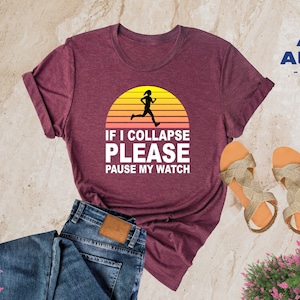 May include: Heather maroon t-shirt with a white graphic of a runner in front of a sunset with the text "If I Collapse Please Pause My Watch".