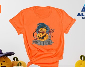 May include: Orange t-shirt with a graphic of a pumpkin wearing a witch hat and holding a pitchfork. The text "ALPINE -DESIGN- " is in the top right corner of the image.