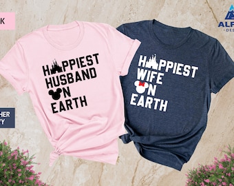 May include: Two t-shirts, one pink and one heather navy, with a matching design. The pink t-shirt says "Happiest Husband on Earth" with a Mickey Mouse head and a castle graphic. The navy t-shirt says "Happiest Wife on Earth" with a Minnie Mouse head and a castle graphic.