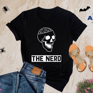 May include: Black t-shirt with a white skull graphic and the text "THE NERD".