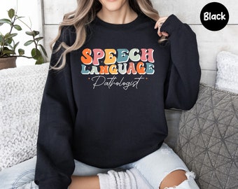 May include: Black sweatshirt with the text "Speech Language Pathologist" in rainbow letters.