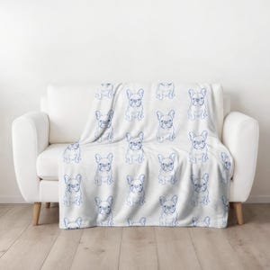 May include: White fleece throw blanket with a blue repeated pattern of French Bulldog silhouettes.