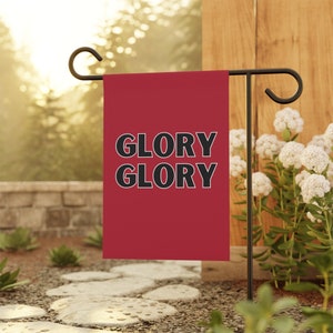 May include: A red garden flag with the text "GLORY GLORY" in black lettering.