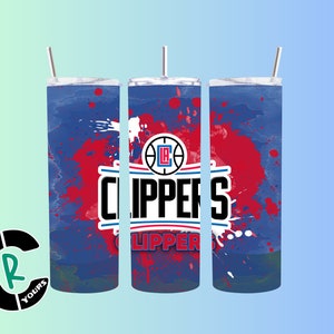 May include: Three stainless steel tumblers with a blue and red paint splatter design. The tumblers feature the Los Angeles Clippers logo and the team name.