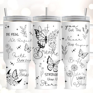 May include: White tumbler with a handle and a silver lid, featuring black and white inspirational quotes and butterfly designs. The tumbler includes the phrases "Be Real, Not Perfect," "Just Breathe," and "You Got This."