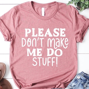 May include: A dusty rose t-shirt with the text "PLEASE DON'T MAKE ME DO STUFF!" printed in white.