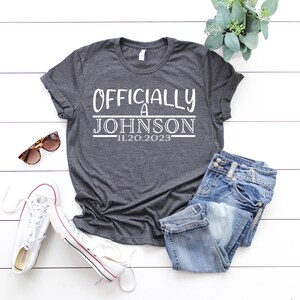 May include: A gray t-shirt with the text "Officially a Johnson 11.20.2023" printed in white.