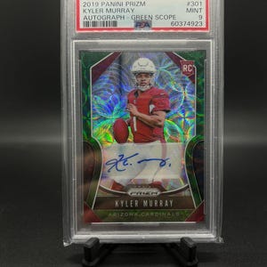 May include: A graded trading card of Kyler Murray, a football player for the Arizona Cardinals. The card is from the 2019 Panini Prizm Green Scope Autograph set and is graded a 9 by PSA. The card features a holographic design with a green background and a picture of Murray in his Cardinals uniform. The card also includes Murray's autograph.