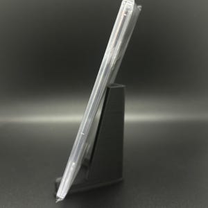 May include: A clear plastic CD case with a black stand. The case is empty.