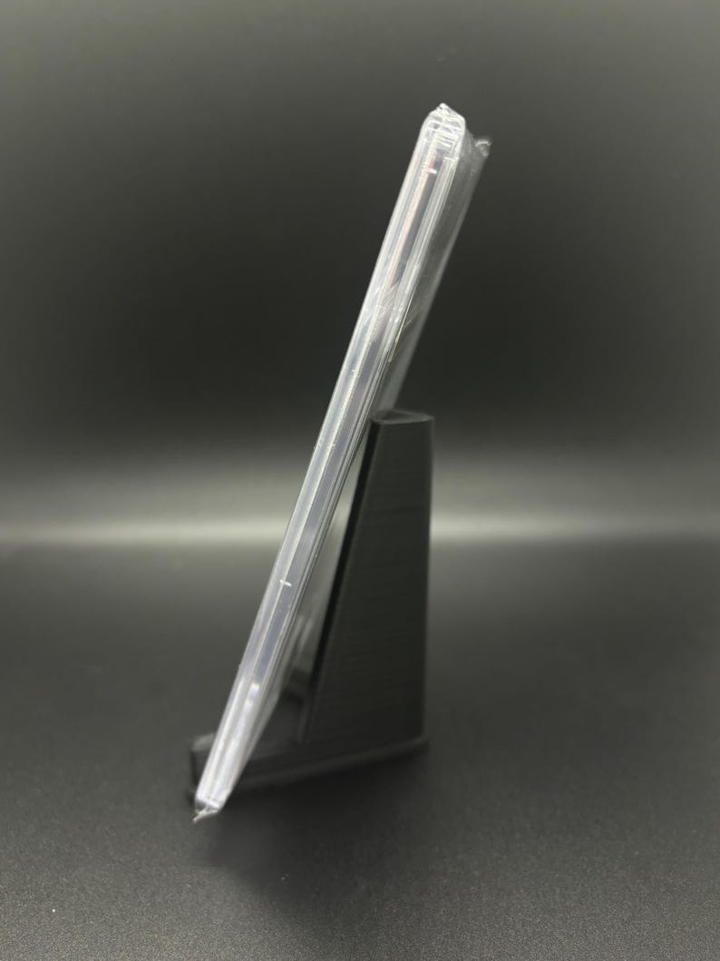 May include: A clear plastic CD case with a black stand. The case is empty.
