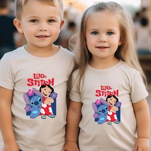 May include: Two children wearing beige t-shirts with a graphic of Lilo and Stitch from the Disney movie. The shirts feature the text "Lilo & Stitch" in red and blue.